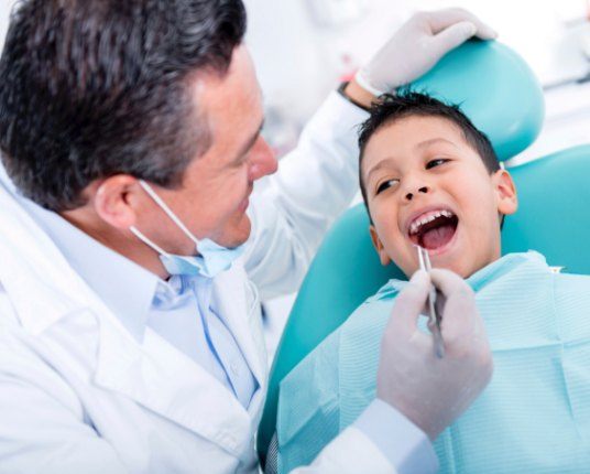 Dentist examining patient's smile during dentistry for children visit